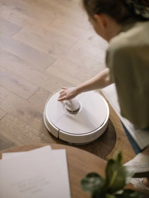 Cleaner using a vacuum in a stylish indoor setting, showcasing cleaning equipment and techniques.